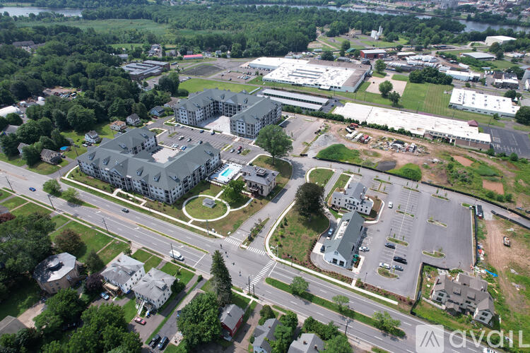 An aerial view of a large building complex surrounded by a parking lot and other buildings.