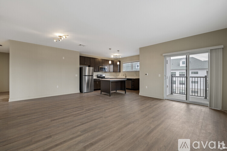 A spacious living room with a kitchenette in the background.
