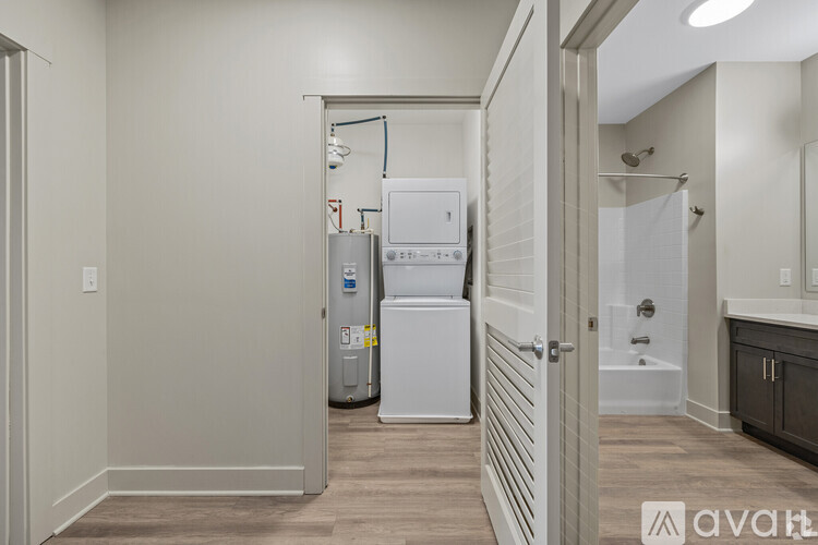 A small white refrigerator sits in a narrow hallway.