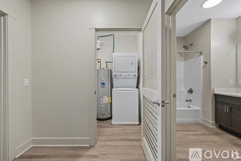 A small white refrigerator sits in a narrow hallway.