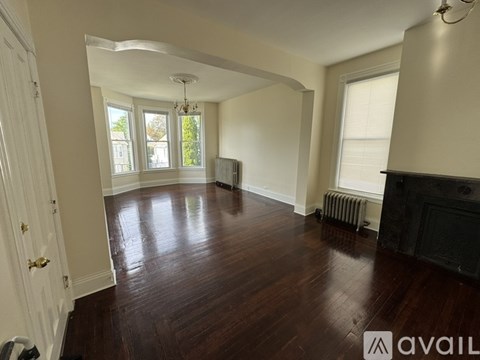 A spacious room with wood flooring and a fireplace.