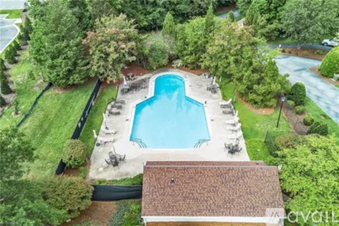 A swimming pool surrounded by trees and a house.