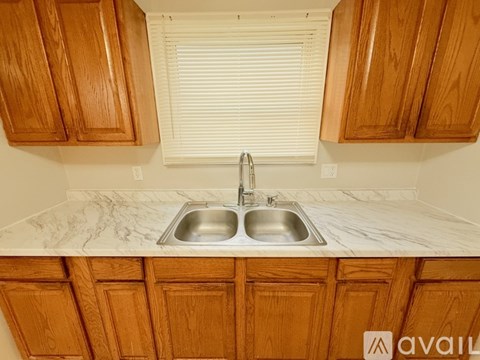 A kitchen with wooden cabinets and a marble countertop.
