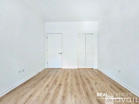 A room with two doors and wooden flooring.