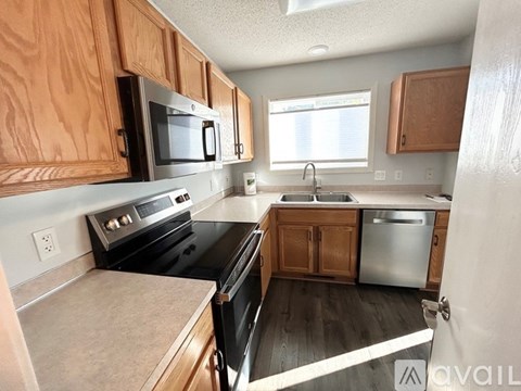 A kitchen with wooden cabinets and black appliances.