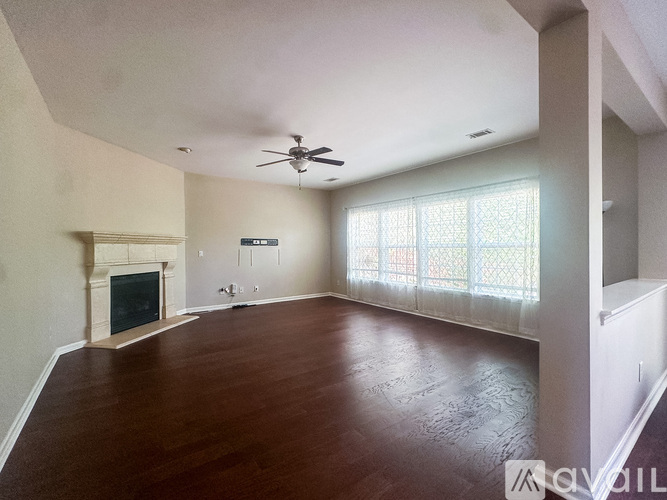 A living room with a fireplace and a ceiling fan.