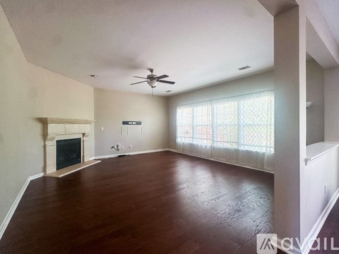 A living room with a fireplace and a ceiling fan.