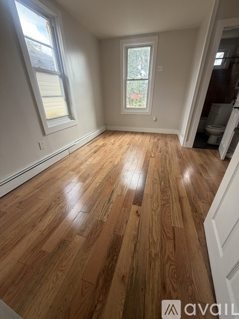 A room with wooden flooring and a window.