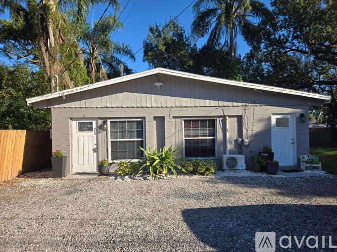 A house with a gravel driveway and a wooden fence.