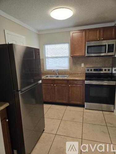 A kitchen with a black fridge, microwave, and stove.