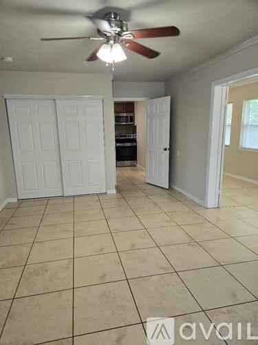 A room with a ceiling fan and tile flooring.