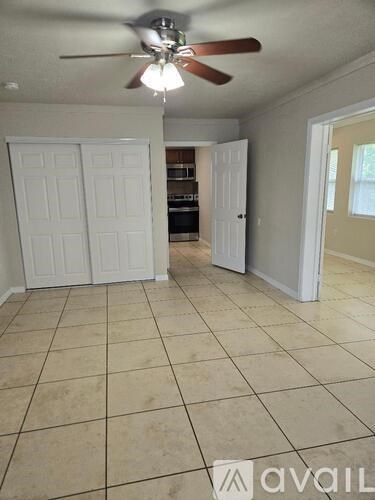 A room with a ceiling fan and tile flooring.