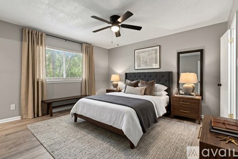 A bedroom with a large bed and a ceiling fan.