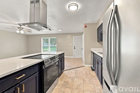 A kitchen with black cabinets and a stainless steel refrigerator.