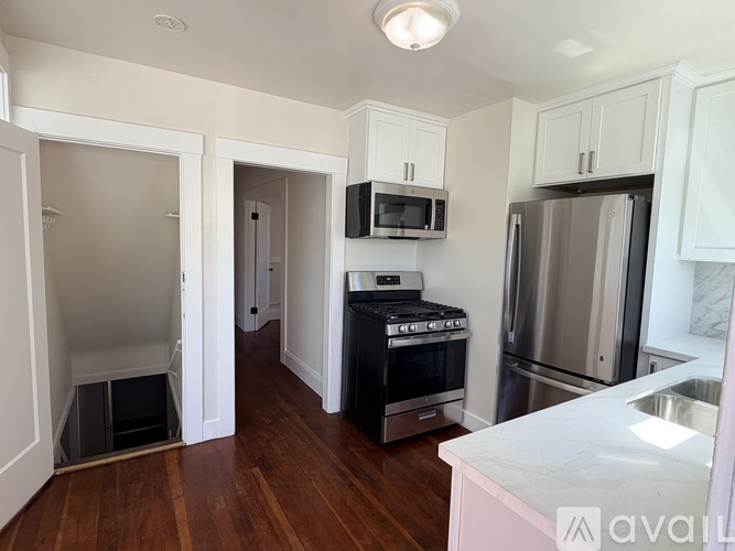 A kitchen with a stove top oven, microwave, refrigerator, and sink.