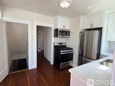 A kitchen with a stove top oven, microwave, refrigerator, and sink.