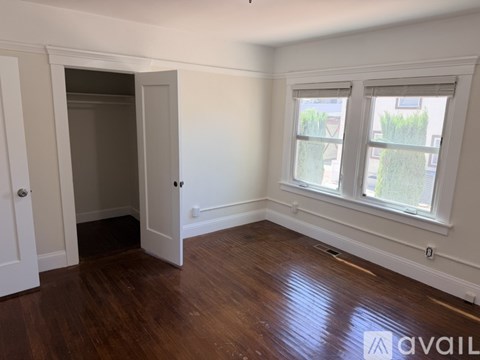A room with a doorway leading to another room and a window with a view of a building.