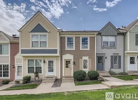 A row of houses with different designs and front yards.