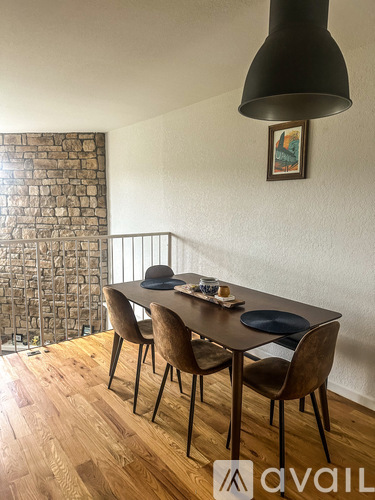 A dining room with a wooden table and chairs.