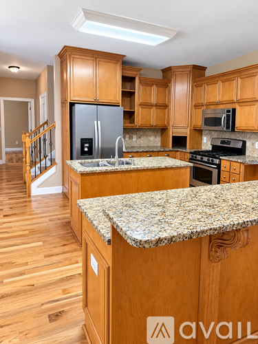 A kitchen with wooden cabinets and a granite countertop.