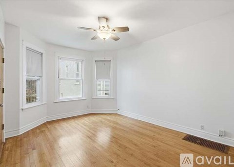A room with wooden floors and a ceiling fan.