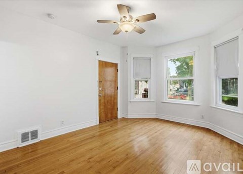 A room with a ceiling fan and wooden floors.