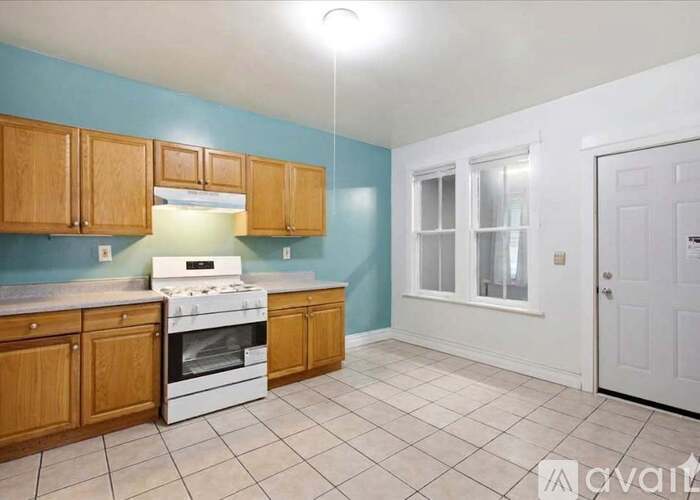 A kitchen with wooden cabinets and a white stove top oven.