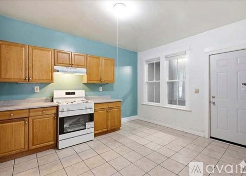 A kitchen with wooden cabinets and a white stove top oven.