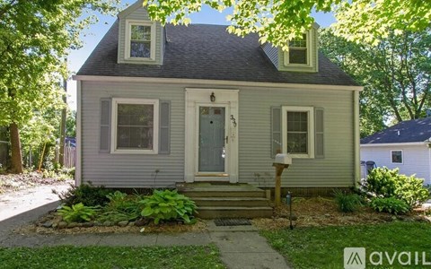 A small house with a front yard and a flag on the front porch.