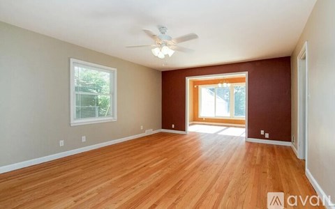 A room with wooden floors and a ceiling fan.