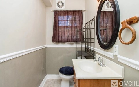 A bathroom with a toilet, sink, and mirror.