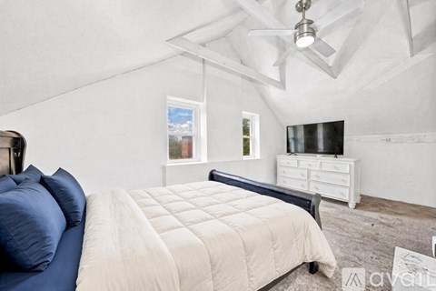 A bedroom with a bed, dresser, and window.