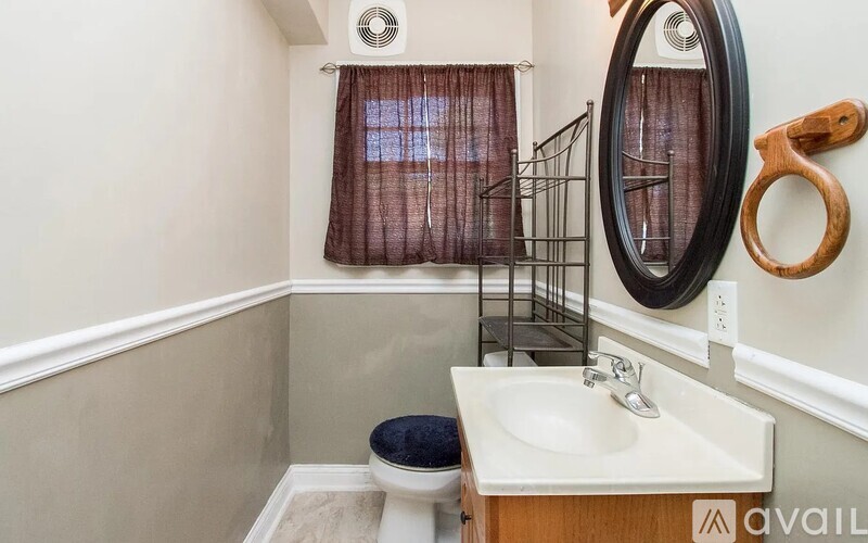 A bathroom with a toilet, sink, and mirror.