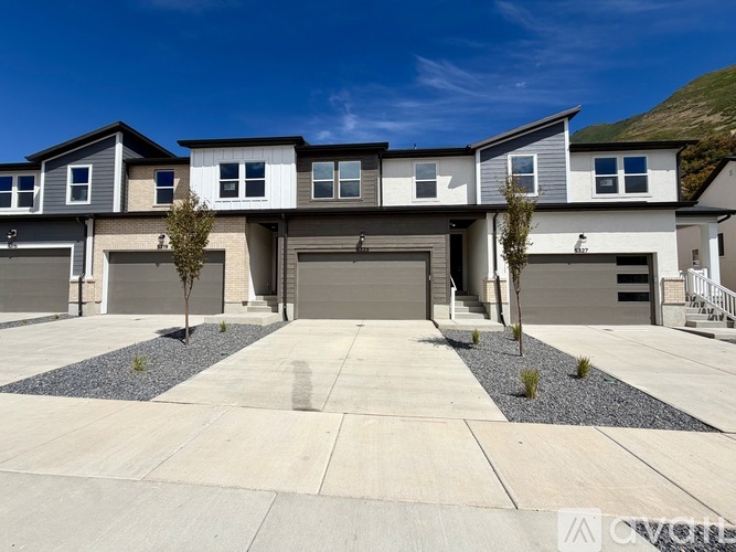 A modern house with a grey garage door in the front.