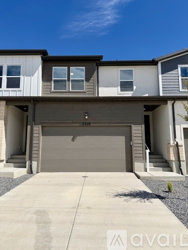 A modern house with a grey garage door is for sale.