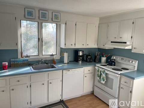 A kitchen with white cabinets and a blue backsplash.