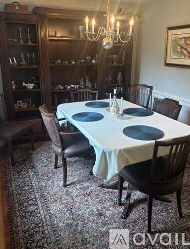 A dining room with a round table set for six.