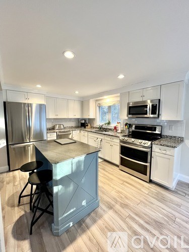 A kitchen with a table and chairs in front of a refrigerator.