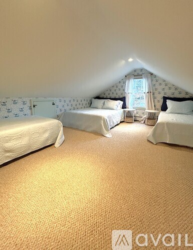 A bedroom with two beds and a window.