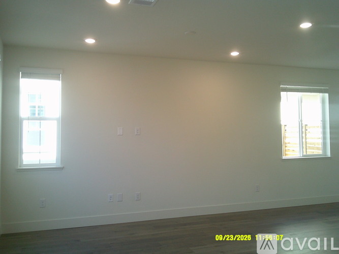A room with two windows and a wooden floor.