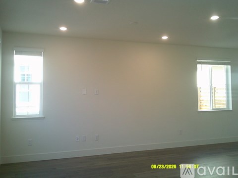 A room with two windows and a wooden floor.