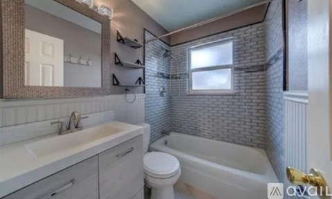 A bathroom with a white sink, toilet, and bathtub.