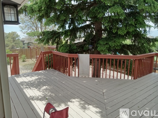 A deck with a red chair and a lamp post.