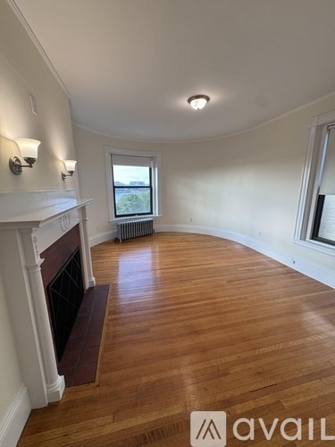 A living room with a fireplace and wood flooring.