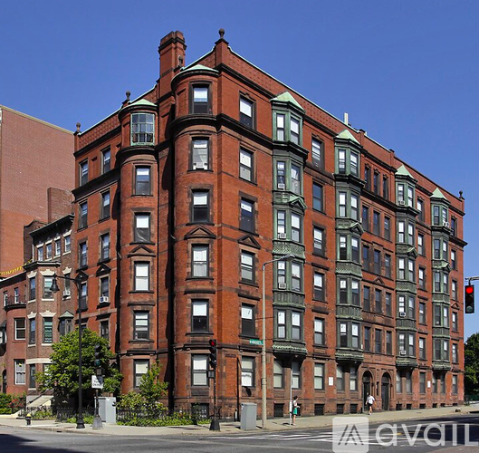 A large red brick building with green trim and many windows.