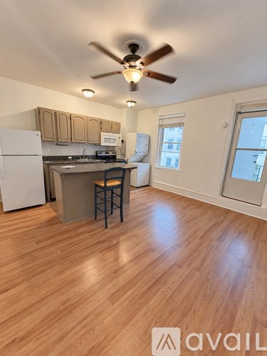 A kitchen with wooden floors and a ceiling fan.