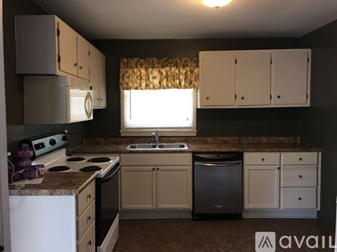 A kitchen with white appliances and cabinets.
