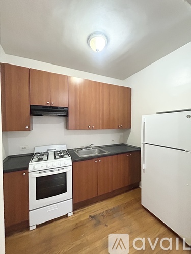 A kitchen with wooden cabinets and a white stove top oven.