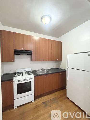 A kitchen with wooden cabinets and a white stove top oven.