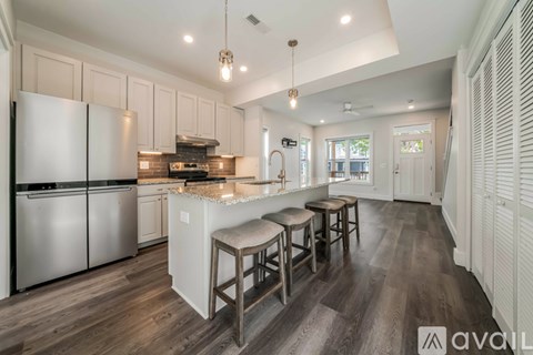 A kitchen with white cabinets and a wooden floor.